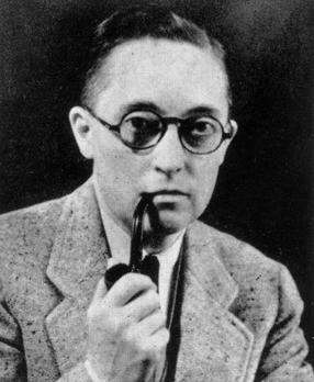 A black and white photograph of Alan L. Hart wearing a light-colored suit and round glasses, holding a pipe close to his mouth. His expression is thoughtful, and he gazes directly at the camera.