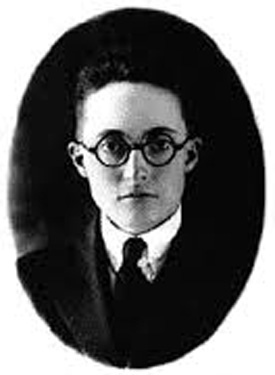 A vintage black and white portrait of a younger Alan L. Hart, wearing a dark suit and tie with round glasses. His serious expression and neatly styled hair contribute to a formal appearance.