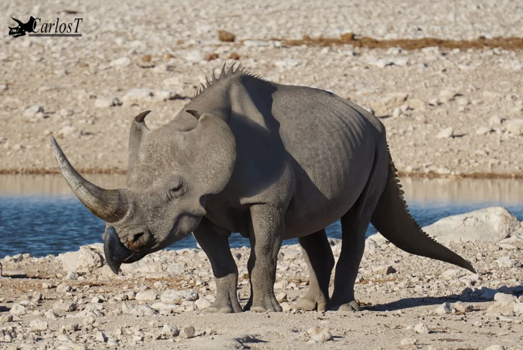 A digitally manipulated image of a rhinoceros-like creature for Emela-Ntouka with a long, thick horn extending forward, a crocodilian-like tail, and ridges along its back, standing in a dry, rocky landscape near a water source.