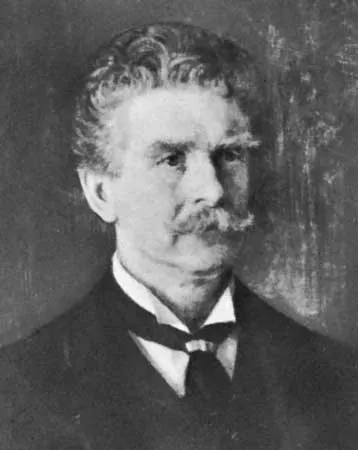 A grayscale image of Ambrose Bierce in middle age. He has a mustache, curled hair, and is dressed in a formal dark suit with a white shirt and a dark cravat.