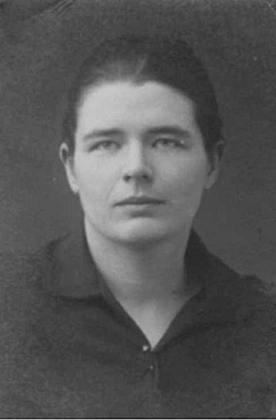 Black-and-white portrait of a young Marguerite Yourcenar, with a neutral expression, dark hair pulled back, wearing a plain collared top.